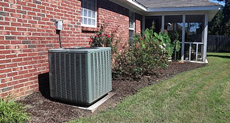 Air conditioner system next to a home outdoors